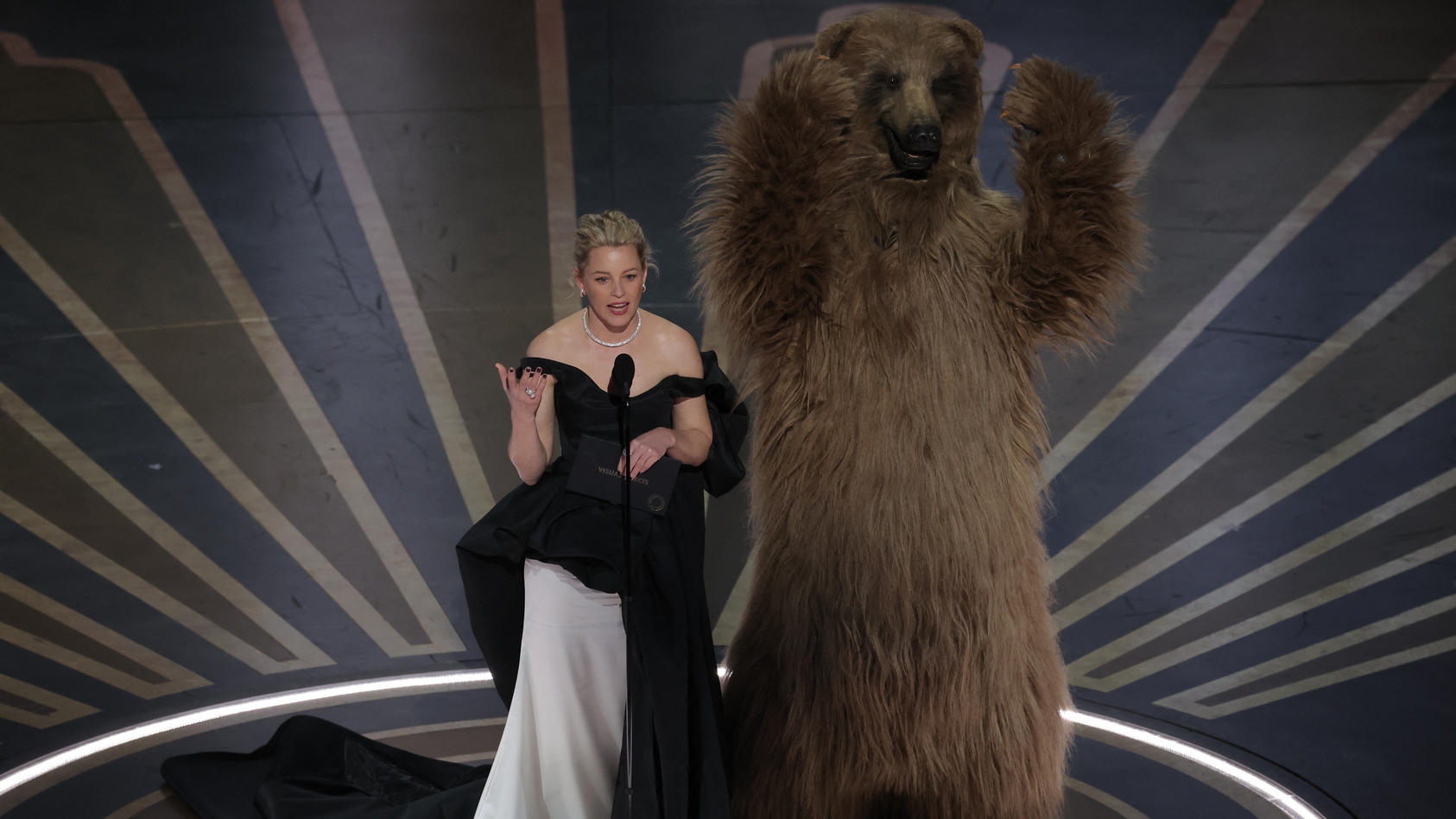 Elizabeth Banks mit einem Bären auf der Bühne der Oscar-Verleihung