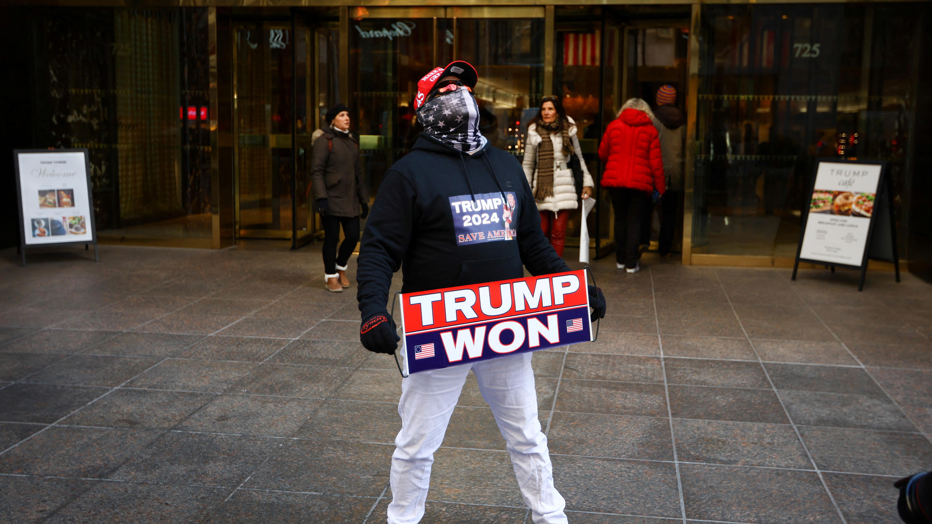 A man who identified himself as Don Cini, a supporter of former U.S. President Donald Trump, holds a Trump campaign sign outside Trump Tower in midtown Manhattan in New York City, New York, U.S., March 20, 2023. REUTERS/Mike Segar