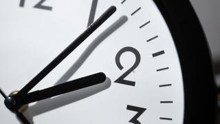 Die Zeiger einer analogen Uhr stehen zwischen zwei und drei Uhr