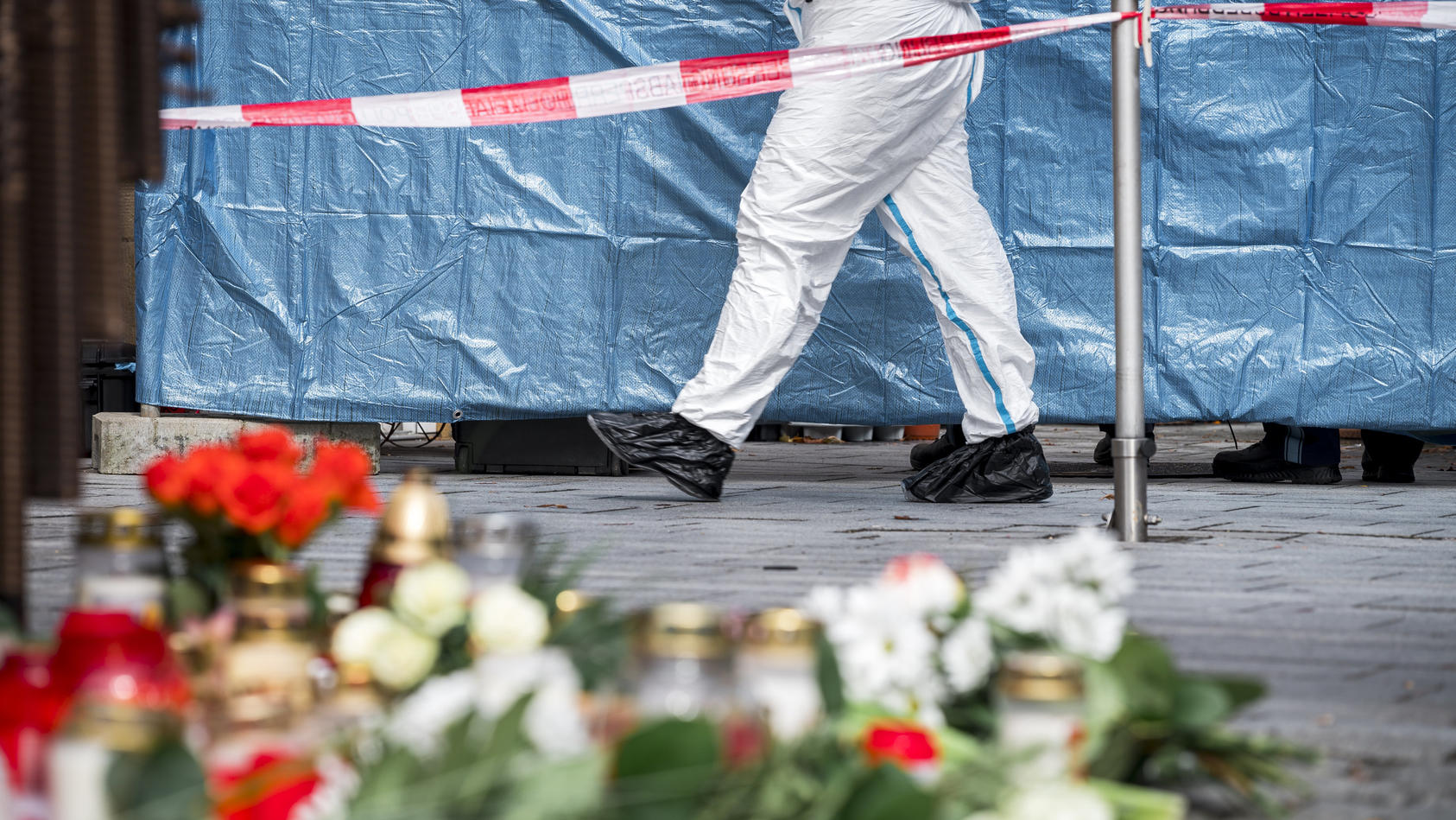 13.03.2023, Bayern, Lichtenfels: Ein Mitarbeiter der Spurensicherung geht in den abgesperrten Bereich vor dem Blumengeschäft, in dem am Freitagabend eine leblose Frau aufgefunden wurde. Spaziergänger hatten die tote 50-Jährige in dem Blumenladen in d