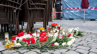 13.03.2023, Bayern, Lichtenfels: Auf dem Platz vor dem Blumengeschäft, in dem am Freitagabend Mitarbeiterin tot aufgefunden wurde, sind Blumen und Kerzen niedergelegt. Spaziergänger hatten die tote 50-Jährige in dem Blumenladen in der Lichtenfelser Innenstadt entdeckt. Foto: Daniel Vogl/dpa +++ dpa-Bildfunk +++