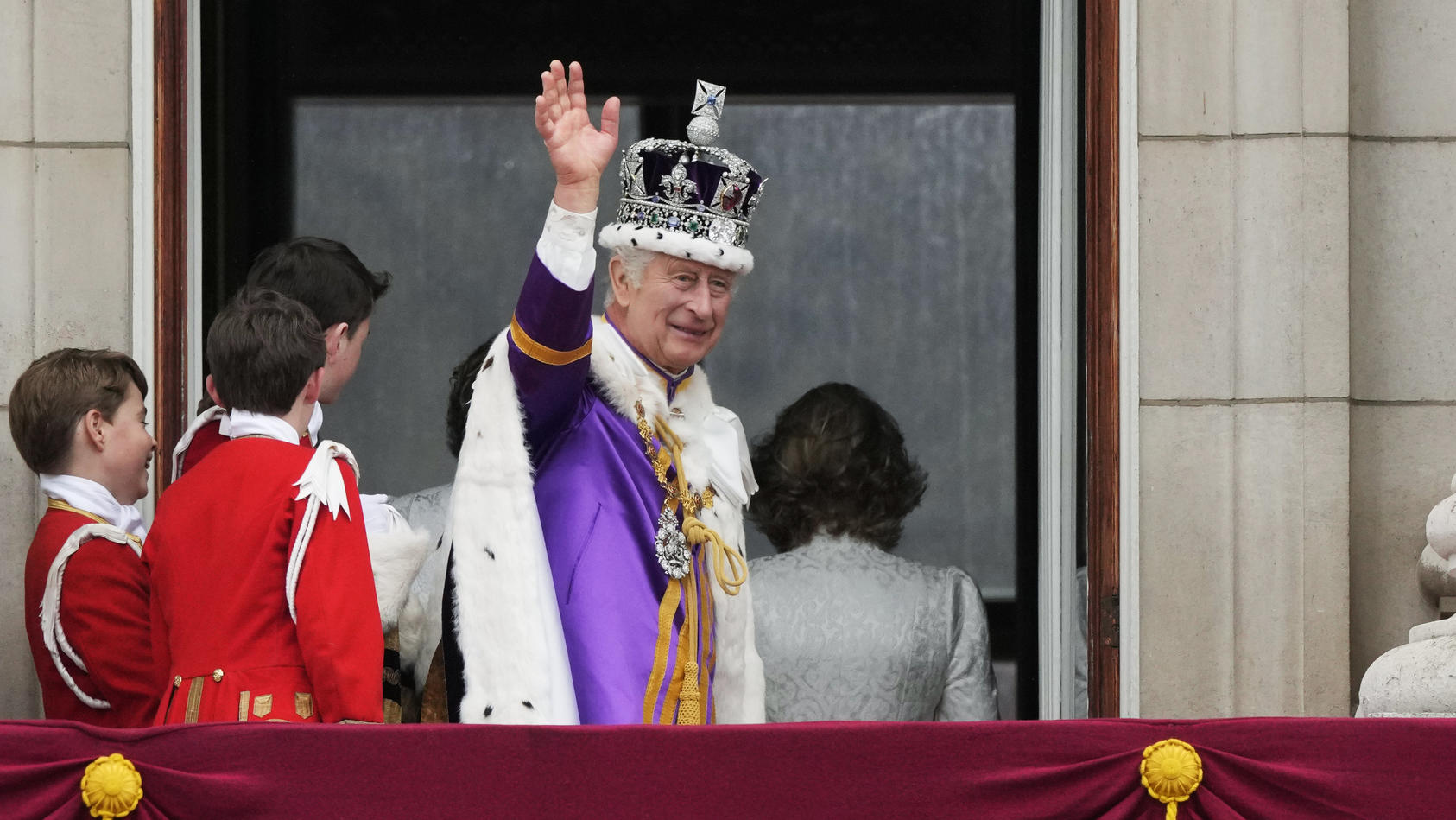 06.05.2023, Großbritannien, London: König Charles III. winkt nach der Krönungszeremonie vom Balkon des Buckingham Palastes aus der Menge zu. Charles und Camilla sind zu König und Königin gekrönt worden - vor den Augen zahlreicher prominenter Gäste au