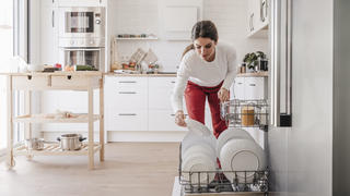 Frau räumt Spülmaschine ein