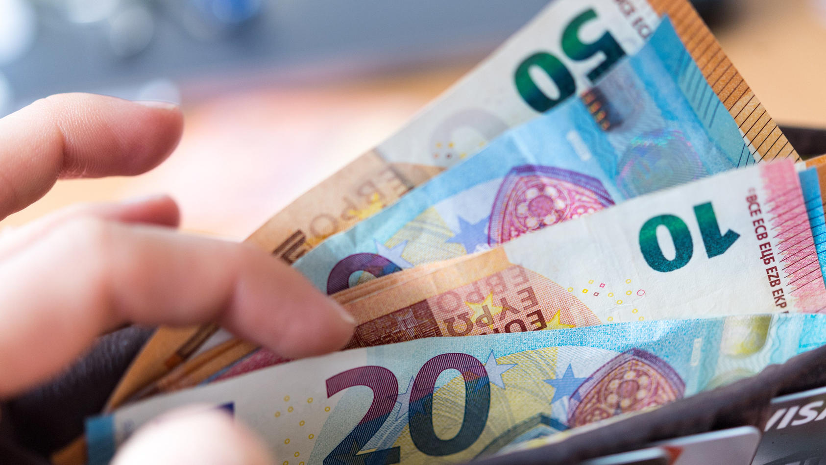 ARCHIV - 04.12.2018, Sachsen, Dresden: Eine Frau hält eine Geldbörse mit Banknoten in der Hand. (ZU dpa: «Thüringen drohen hohe Kosten für Pensionen») Foto: Monika Skolimowska/dpa-Zentralbild/dpa +++ dpa-Bildfunk +++