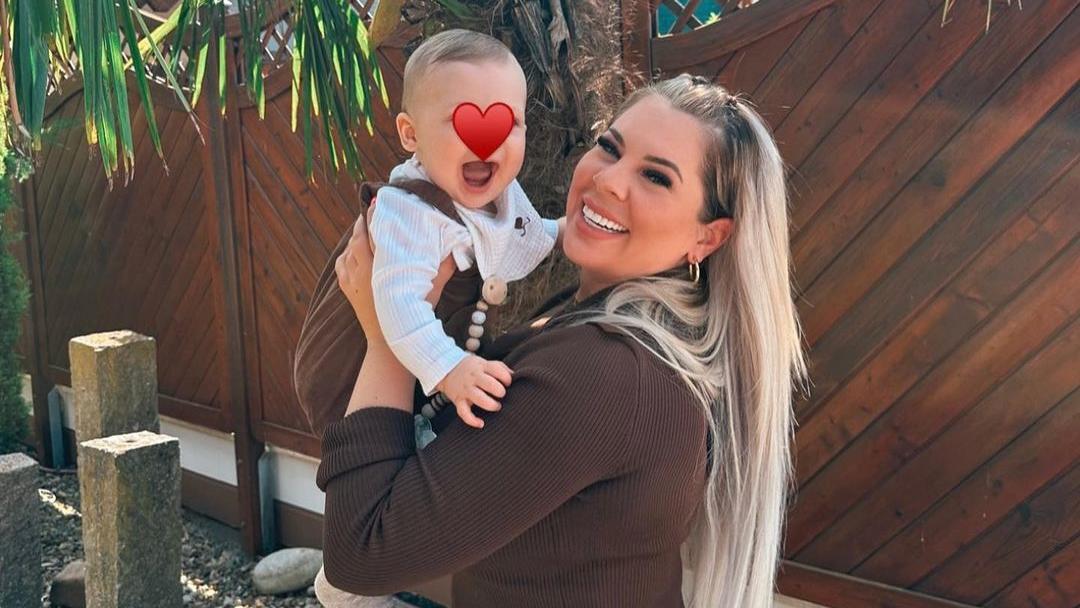 Jenny Frankhauser hat ihren Sohn Damian auf dem Arm. Beide strahlen in die Kamera. Über Damians Gesicht ist ein roter Herz-Emoji.
