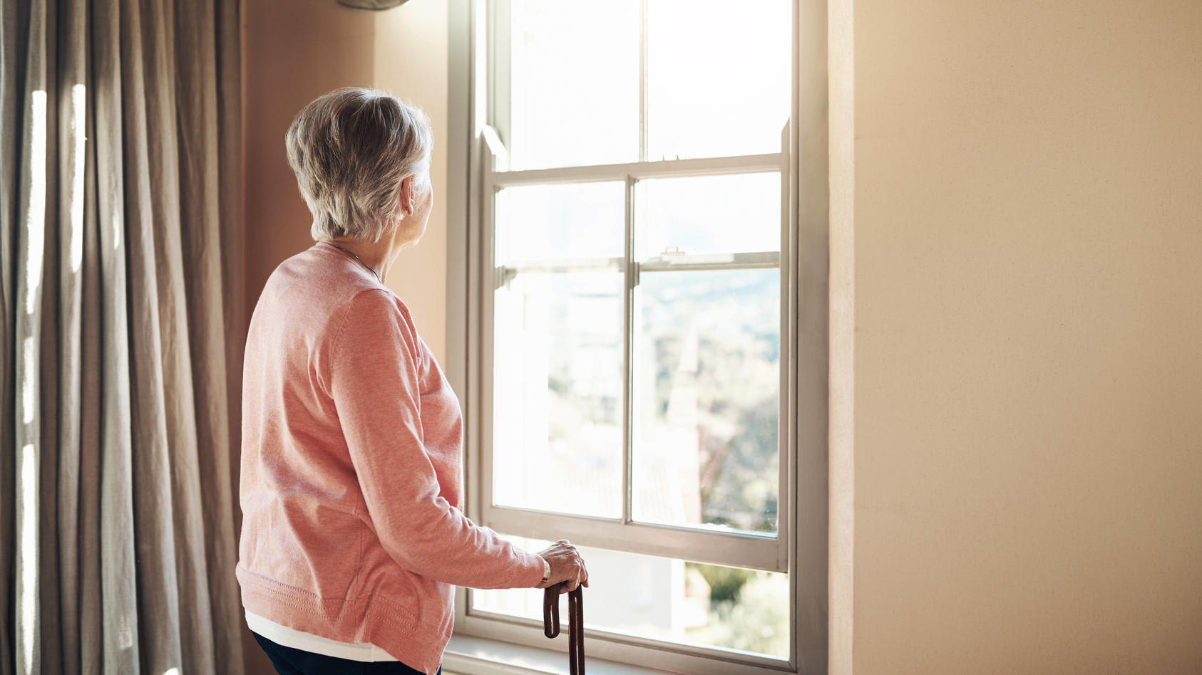 When did the days become so grey. Shot of a senior woman with a cane looking thoughtfully out of a window at home. Shot of a senior woman with a cane looking thoughtfully out of a window at home. Copyright: xZoonar.com/YurixArcursxpeopleimages.comx 1