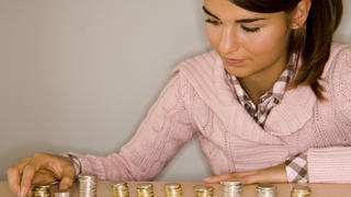 teenager making piles of coins to count her money Keine Weitergabe an Drittverwerter., Royalty free: Bei werblicher Verwendung Preis auf Anfrage