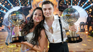 26.05.2023, Nordrhein-Westfalen, Köln: Die Sieger Malika Dzumaev (l) und Zsolt Sándor Cseke (r) stehen bei der "Lets Dance Profi-Challenge" mit ihren Pokalen im Studio. Foto: Henning Kaiser/dpa +++ dpa-Bildfunk +++