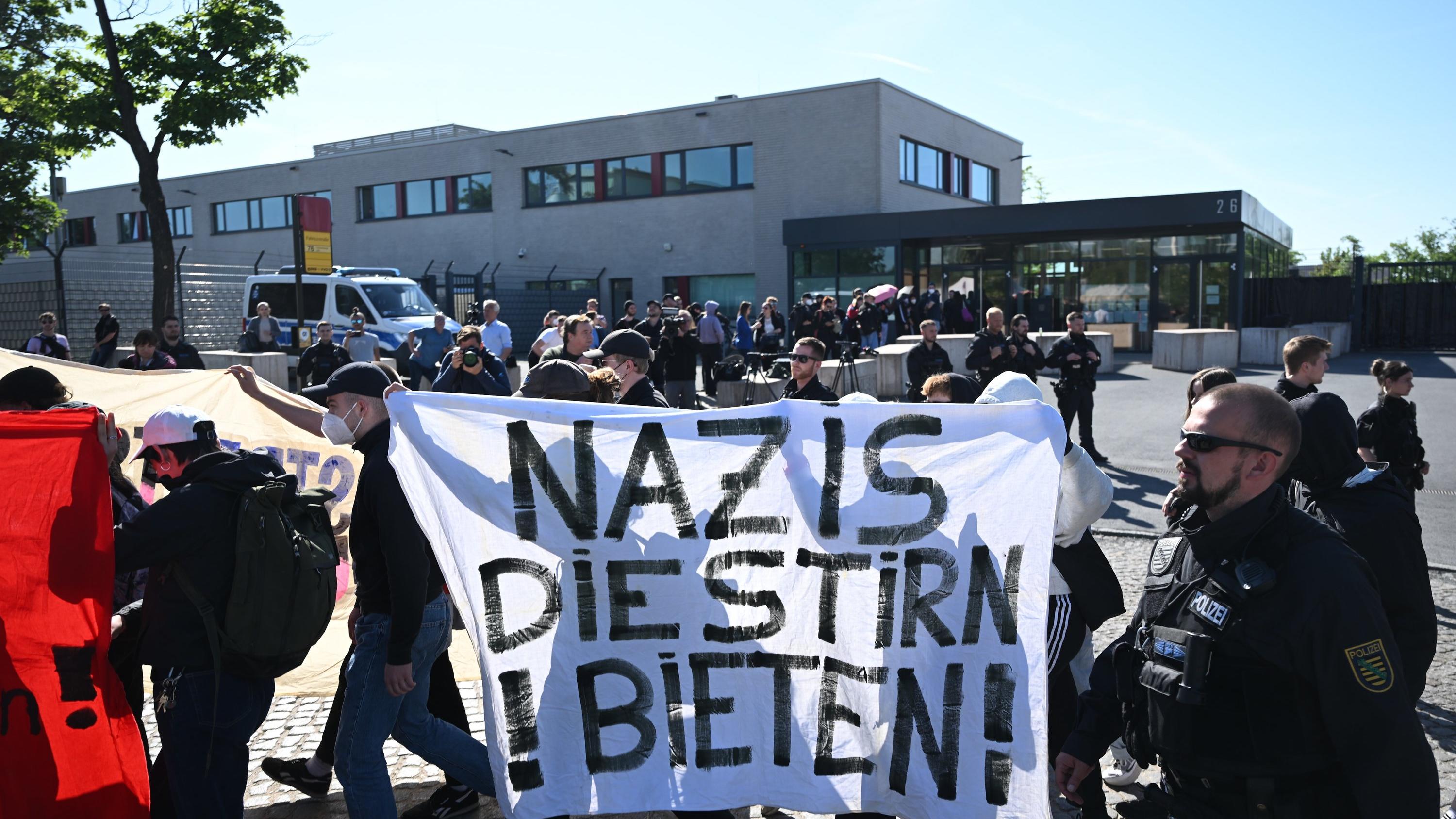 31.05.2023, Sachsen, Dresden: Demonstranten aus dem linken Spektrum laufen vor Beginn der Urteilsverkündung gegen Lina E. und drei Männer vor dem Oberlandesgericht (OLG) Dresden mit einem Banner ·Nazis die Stirn bieten· entlang. Die Gruppe aus der li