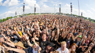 ARCHIV - 04.06.2022, Bayern, Nürnberg: Besucher beim Open-Air-Festival «Rock im Park» nehmen an einem Konzert teil (zu dpa «Teurer Festival-Sommer - Steigende Kosten treiben Ticketpreise»). Foto: Daniel Karmann/dpa +++ dpa-Bildfunk +++