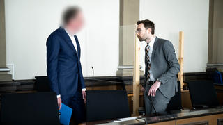 06.06.2023, Niedersachsen, Verden: Der Angeklagte (l) steht vor Prozessbeginn mit seinem Anwalt Sebastian Vogel im Gerichtssaal. Die Staatsanwaltschaft wirft dem Angeklagten Arzt vor, im April 2018 in einem Krankenhaus in Rotenburg als behandelnder Arzt an einem 14-jährigen Patienten nach einem Fahrradunfall nicht die notwendige medizinische Behandlung durchgeführt zu haben. Der Mediziner soll eine bestehende Hirnblutung nicht erkannt haben. Der Jugendliche starb im Krankenhaus. Foto: Sina Schuldt/dpa - ACHTUNG: die Person wurde aus rechtlichen Gründen gepixelt +++ dpa-Bildfunk +++