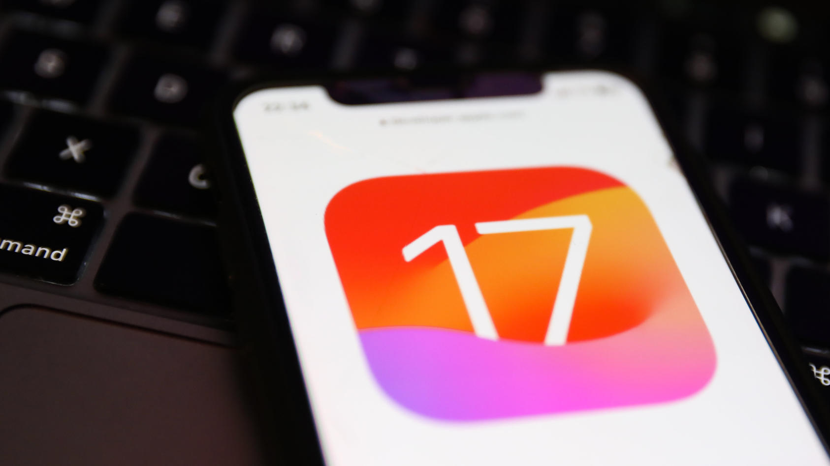 iphone-mit-ios-17-logo-mit-macbook-tastatur-im-hintergrund