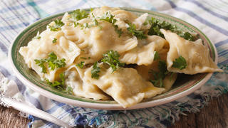 Swabian cuisine: Maultaschen dumplings stuffed with meat and spinach on a plate close-up. horizontal
