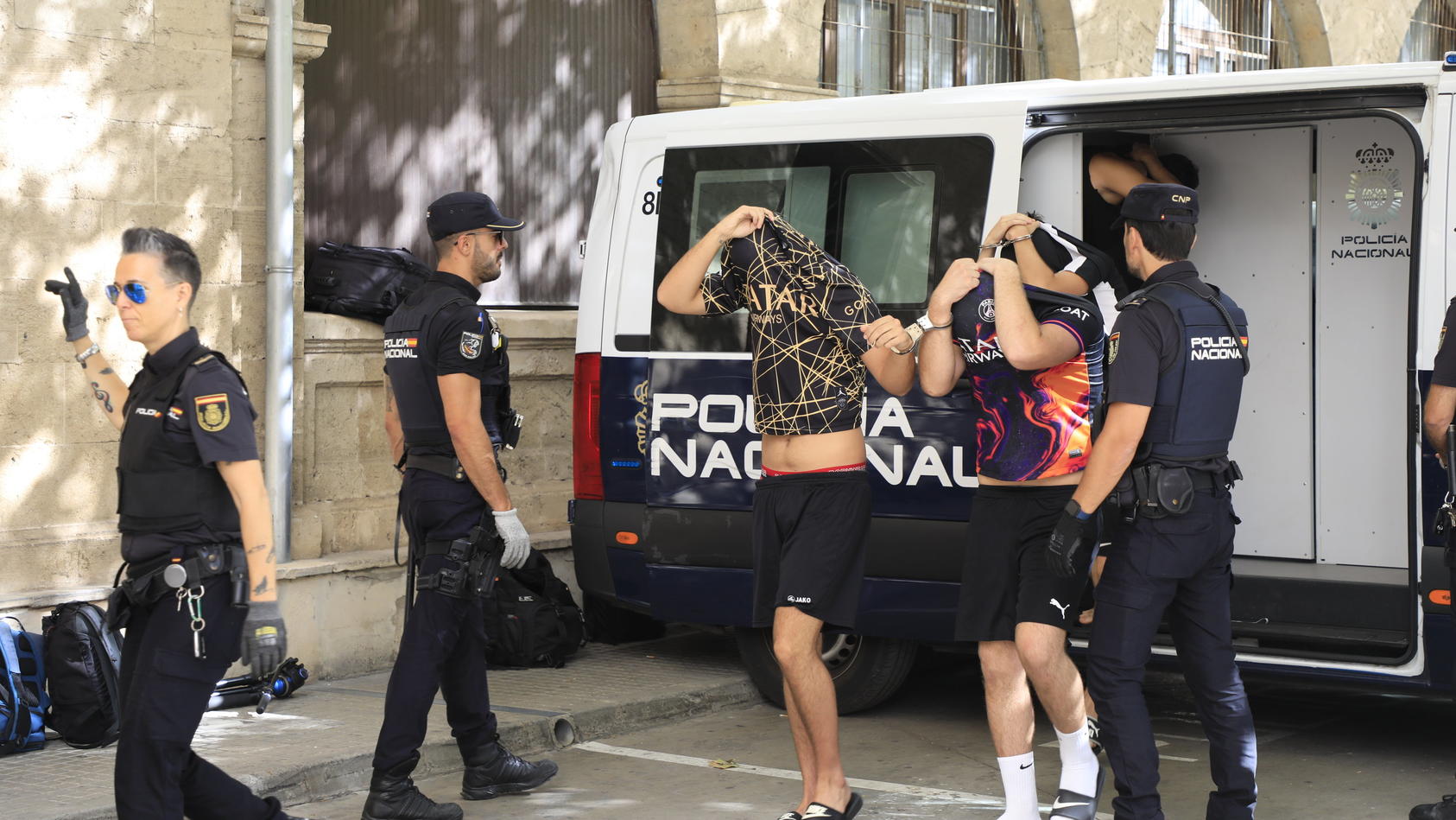 15.07.2023, Spanien, Palma de Mallorca: Polizisten führen die Verdächtigen zum Termin mit dem Haftrichter auf der Balearische Insel. Gegen sechs Urlauber aus Deutschland sind auf Mallorca schwere Vorwürfe erhoben worden. Die Polizei ermittelt wegen e