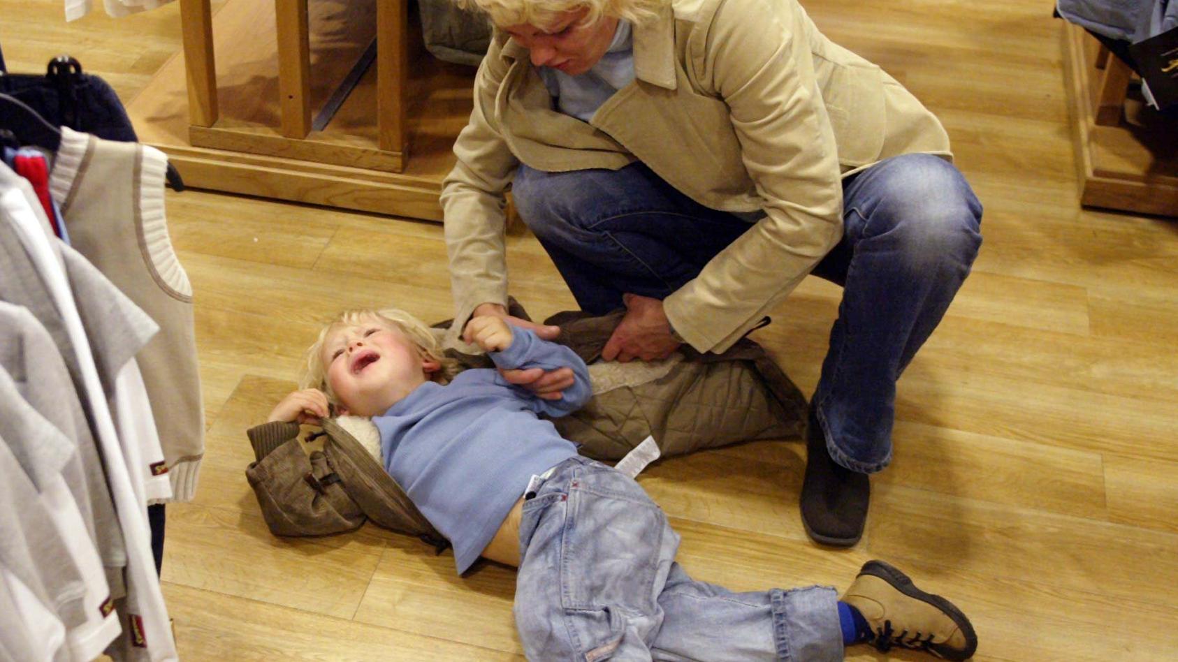 Ein kleines Kind hat sich mitten in einem Modegeschäft schreiend auf den Boden geworfen und will nicht mehr aufstehen. (Aufnahme vom 7.9.2003).