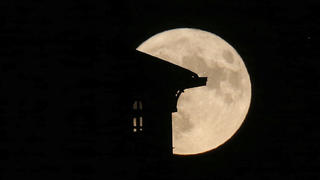 The supermoon rises behind a house in Saint Jean de Luz, southwestern France, Tuesday, Aug.1, 2023. The cosmos is offering up a double feature in August: a pair of supermoons culminating in a rare blue moon.  (AP Photo/Bob Edme)