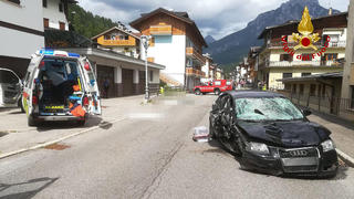HANDOUT - 07.07.2023, Italien, Santo Stefano di Cadore: Ein Krankenwagen und das Auto der Deutschen stehen nach dem Unfall neben den Opfern (gepixelt), die auf einer Straße liegen. Eine Deutsche soll in Norditalien mit ihrem Auto in eine Familie gerast sein und drei Menschen getötet haben. Die Frau wurde nach dem Unfall am Donnerstag, 06.07.2023 festgenommen. Die Frau soll am Donnerstagnachmittag mit ihrem Auto in der Ortschaft nahe der Grenze zu Österreich mit hoher Geschwindigkeit in die Familie gefahren sein. Die Großmutter, der Vater und ein zwei Jahre alter Junge starben bei der Kollision. Die Mutter wurde leicht verletzt. Der Großvater, der offenbar mit etwas Abstand lief, kam wegen eines Schocks in eine Klinik. Foto: -/Vigili del fuoco/dpa - ACHTUNG: Nur zur redaktionellen Verwendung im Zusammenhang und nur mit vollständiger Nennung des vorstehenden Credits; Opfer des Unfalls wurden aus rechtlichen Gründen gepixelt +++ dpa-Bildfunk +++