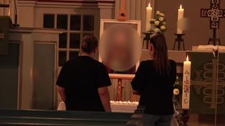 Ein Kirchenaltar geschmückt mit Blumen. Ein Foto von einer Frau steht davor