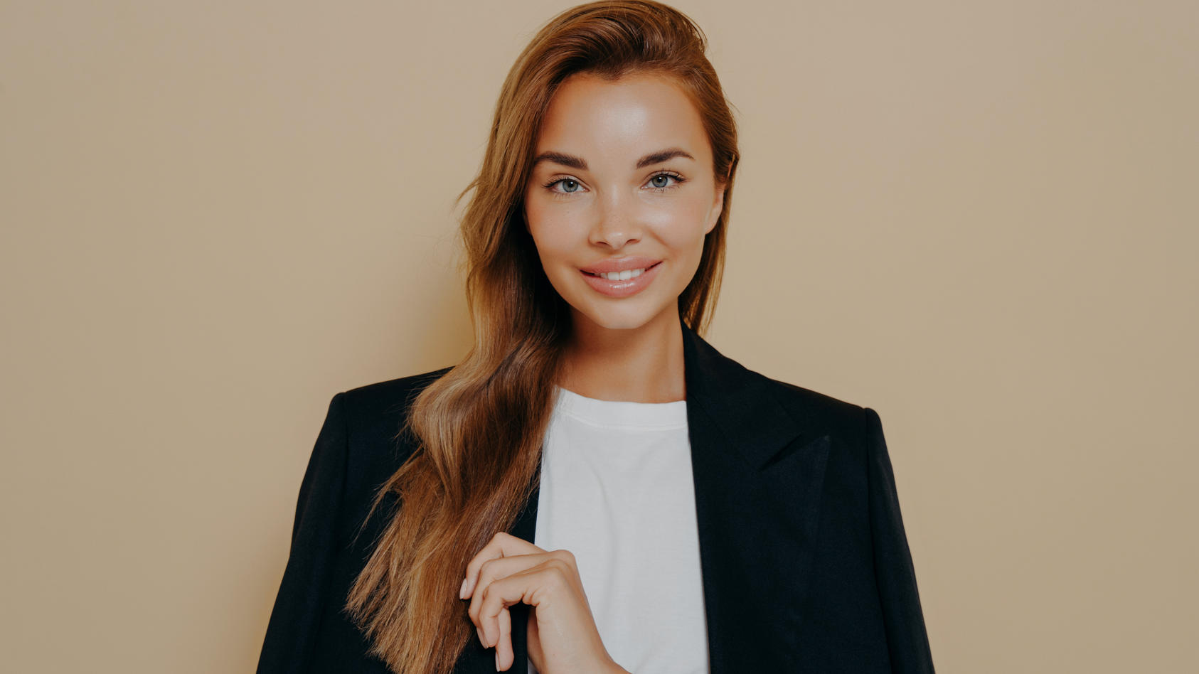 Frau, die einen schwarzen Blazer und ein weißes T-Shirt trägt.