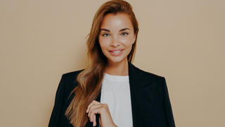 Frau, die einen schwarzen Blazer und ein weißes T-Shirt trägt.