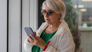 Seniorin, Rentnerin, ältere Frau mit Smartphone, Handy, schreibt SMS oder Whatsapp.