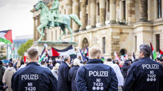 14.10.2023, Niedersachsen, Braunschweig: Polizisten beobachten Demonstranten, die an einer pro-palästinensischen Demonstration auf dem Schlossplatz teilnehmen. Nach dem Terrorangriff der Hamas auf Israel kam es deutschlandweit zu zahlreichen Reaktionen. Foto: Moritz Frankenberg/dpa +++ dpa-Bildfunk +++