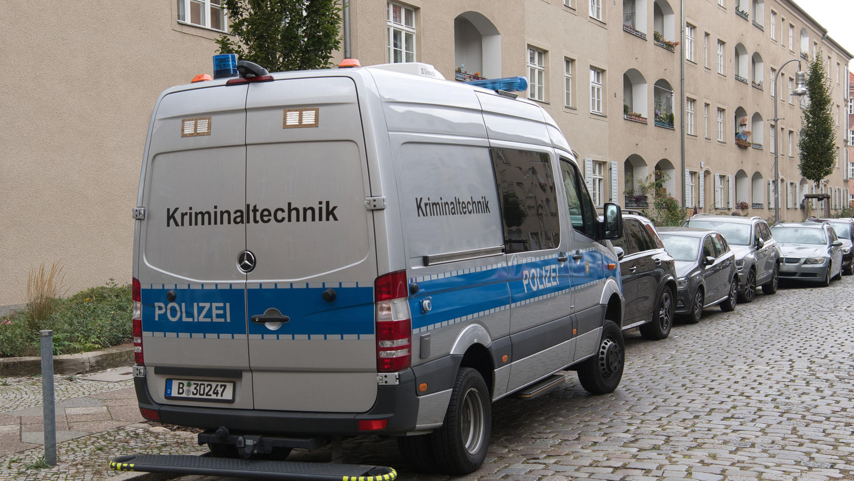 Berlin: Ein Einsatzfahrzeug der Kriminaltechnik der Polizei steht vor einer Häuserzeile an der Kinzerallee im Berliner Stadtteil Köpenick. Dort wurden die Leichen einer Frau und eines Kindes in einer Wohnung gefunden. Eine Mordkommission 