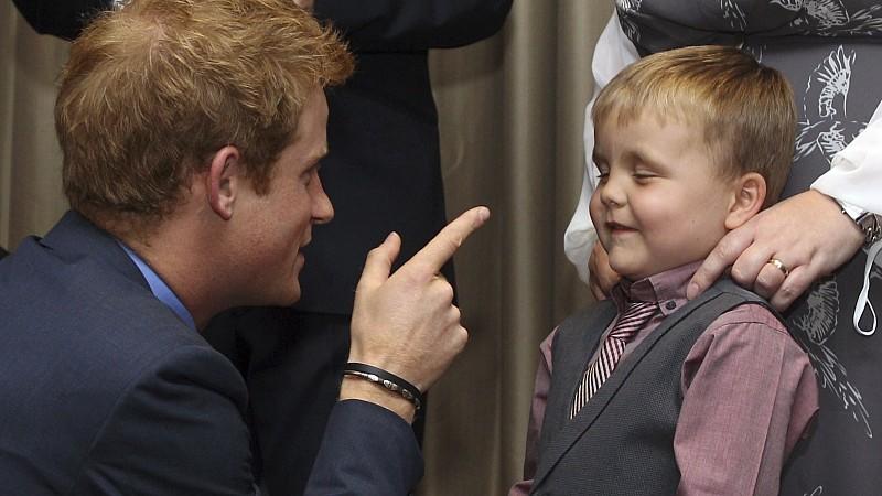 Prinz Harry spaßt mit einem kleinen Jungen