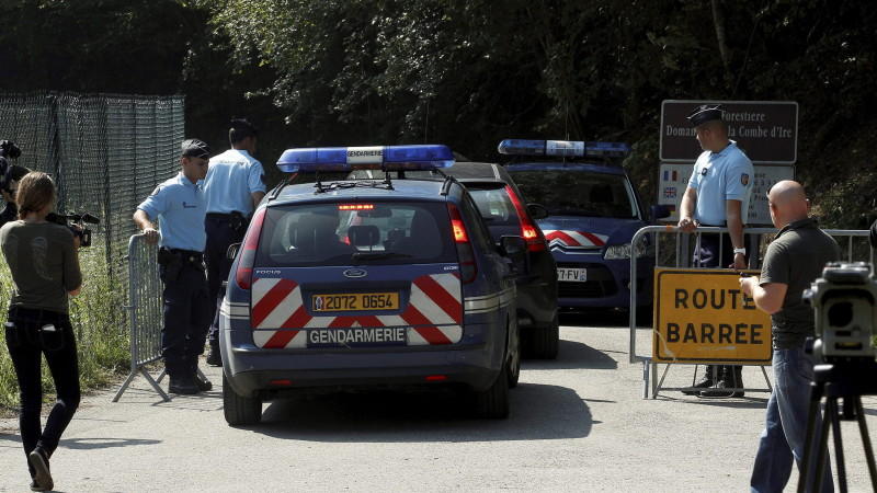 epa03389457 Police cars and officers block reporters and photographers gathered on a road leading to a car park near a camp site in Chevaline near the Annecy Lake, France, 08 September 2012. French prosecutors launched a formal murder investigation F