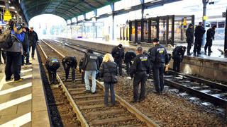 Polizisten untersuchen am 10.12.2012 im Hauptbahnhof in Bonn (Nordrhein-Westfalen) Gleise. Ein Bombenalarm im Bonner Hauptbahnhof hat zu heftigen Störungen im Bahnverkehr geführt. Am Nachmittag war eine verdächtige Tasche gefunden worden. Nach Polizeiangaben handelte es sich um eine funktionstüchtige Rohrbombe. Foto: Volker Lannert/dpa  +++(c) dpa - Bildfunk+++