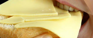 Eine Frau beißt am Dienstag (28.08.2007) in Düsseldorf in ein mit Käse belegtes Brötchen. Den deutschen Verbrauchern stehen nach Branchen-Angaben weitere Preissteigerungen bei Milchprodukten ins Haus. Anstiege bei den verschiedenen Sorten und Marken von Käse, Butter oder Quark seien in den kommenden Monaten immer wieder möglich, zum Teil um die 50 Prozent. Foto: Fredrik von Erichsen dpa/lnw (zu dpa - lnw 7135 vom 28.08.2007) +++(c) dpa - Report+++
