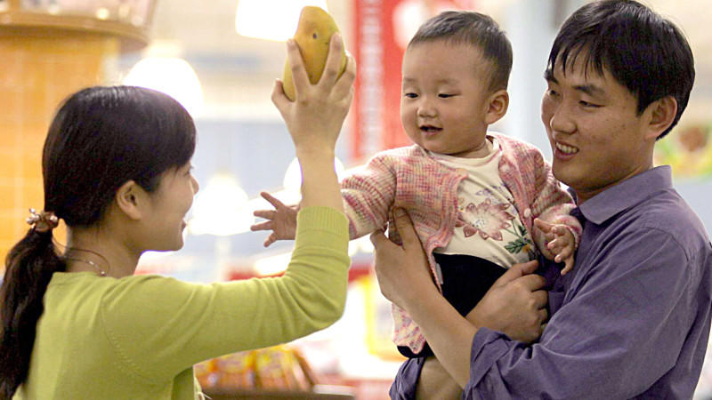 A Chinese couple carrying their kid buy fruits at a supermarket in Shanghai 18 May 2005. Foto:  Omp/Imaginechina +++(c) dpa - Report+++