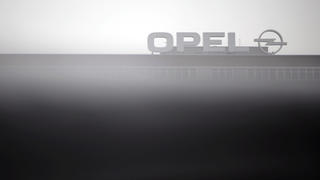 ARCHIV - Der Opel-Schriftzug auf dem Werk in Bochum (Nordrhein-Westfalen) ist am 21.03.2013 hinter einem Autodach zu sehen. Der Betriebsratsvorsitzende des Bochumer Opel-Werks, Rainer Einenkel, hat die Strategie der IG Metall bei den Verhandlungen über den Sanierungsplan für den angeschlagenen Autobauer kritisiert. Foto: Marius Becker/dpa +++(c) dpa - Bildfunk+++