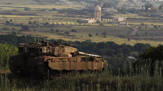epa03689241 Israeli tanks taking positions on the Israeli-Syrian border, next to the Syrian village of Ber Ajam (background), in the Golan Heights, 06 May 2013, day after the Israeli airstrikes on a military research centre near Damascus, Syrian official said that the strike hit elite Republican Guard units and Syria would retaliate against Israel in its own time and way. EPA/ATEF SAFADI +++(c) dpa - Bildfunk+++