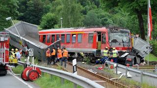 Die Trümmer eines Personenzuges und eines Sattelschleppers liegen am 21.06.2013 in Bad Laasphe (Nordrhein-Westfalen) auf einem Bahnübergang an der Bundesstraße 62. Bei dem Unfall sind 32 Menschen verletzt worden. Foto: Henning Kaiser/dpa +++(c) dpa - Bildfunk+++