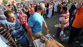 epa03780398 Members of the Muslim Brotherhood carry the body of a dead supporter of ousted president Morsi, during clashes with Republican guards forces in Cairo, Egypt, 08 July 2013. According to local sources, supporters of ousted president Morsi clashed during a sit-in outside the Republican guards barracks, early 08 July, tear gas and gunfire were used, at least 10 people are reported killed. Egyptian army armored vehicles were deployed near Tahrir square in order to secure it. EPA/MOHAMMED SABER +++(c) dpa - Bildfunk+++