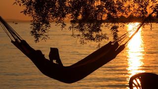 Eine Frau liest am Samstag (20.08.2011) in einer Hängematte am Badestrand eines Campingplatzes in Lindau (Schwaben) ein Buch. Ideales Strand- und Badewetter herrscht derzeit am Bodensee. Die Temperaturen steigen bis auf 32 Grad. Foto: Karl-Josef Hildenbrand dpa/lby/lsw  +++(c) dpa - Bildfunk+++