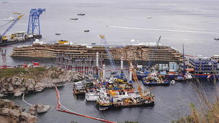epa03870786 A general view showing the shipwrecked cruise ship Costa Concordia in an upright position after the salvage operations in Giglio island, Italy, 17 September 2013. Salvage crews pulled off a major engineering feat when they straightened the listed Costa Concordia cruise ship from the rocks it had been wedged against for the past 20 months. The delicate operation took 19 hours and was completed at 4 am (0200 GMT). The vessel ran aground near the island of Giglio, in Tuscany, in an accident that made world-wide news. EPA/RICCARDO DALLE LUCHE +++(c) dpa - Bildfunk+++