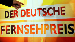 ARCHIV - Eine Hand zeigt am 22.09.2010 am Rande einer Pressekonferenz zu den Nominierungen auf das Logo des Deutschen Fernsehpreises. Am Mittwoch werden in Köln die Deutschen Fernsehpreise verliehen. Foto: Jens Kalaene/dpa +++(c) dpa - Bildfunk+++