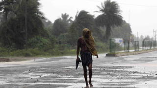 epa03907458 An Indian man walks in a heavy rain shower in district Ganjam in Orissa, India, 12 October 2013. Cyclone Phailin has made landfall on India's south-eastern Orissa state, bringing fierce winds and heavy rains that uprooted trees and power lines. The storm, packing winds around 200 kilometres per hour barrelled in from the Bay of Bengal to make landfall near the coastal town of Gopalpur, Indian Meteorological Department director LS Rathore said. EPA/STR +++(c) dpa - Bildfunk+++