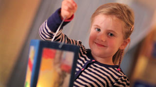 Die fünfjährige Milla zeigt in einem Kindergarten in Lübbecke (Nordrhein-Westfalen) am 05.11.2013 ihre selbstgebastelte Laterne. Um den Martinstag am 11. November ziehen in zahlreichen Regionen Kinder mit ihren beleuchteten Laternen durch die Strassen. Foto: Oliver Krato/dpa +++(c) dpa - Bildfunk+++