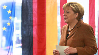 Bundeskanzlerin Angela Merkel (CDU, r) steht am 22.09.2013 in Berlin in einem Wahllokal, um ihre Stimme für die Bundestagswahl abzugeben.   Foto: Michael Kappeler/dpa +++(c) dpa - Bildfunk+++