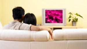 A couple watching television in the living room