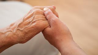 Eine Pflegekraft hält am 24.07.2012 in einem Seniorenheim in Hannover die Hand einer alten Frau.