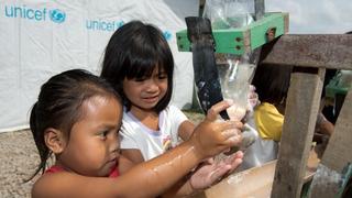 ARCHIV - Grundschulkinder waschen sich am 11.03.2014 in der Manlurip Grundschule in Tacloban Stadt an einem "Tipi Tap", einer Vorrichtung, die aus einer Regenrinne und darüber angebrachten Plastikflaschen aus denen Wasser tropft besteht, die Hände. Jeden Tag sterben 1400 Kinder unter fünf Jahren an Durchfallerkrankungen, ausgelöst durch verschmutztes Trinkwasser, fehlende Toiletten und mangelnde Hygiene, teilte das Kinderhilfswerk Unicef am 21.03.2014 zum Weltwassertag am 22.03.2014 mit. Foto: Frank May/dpa (zu dpa "768 Millionen Menschen fehlt sauberes Trinkwasser" vom 20.03.2014) +++(c) dpa - Bildfunk+++