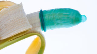 Kondom mit Banane Symbol für Verhütung und Ansteckung durch Aids