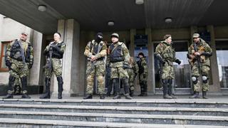 Pro-Russian armed men stand guard outside the mayor's office in Slaviansk April 14, 2014. Towns in eastern Ukraine on Monday braced for military action from government forces after Kiev gave pro-Russian separatists a 9 a.m. (0600 GMT) deadline to disarm and end their occupation of state buildings or face a major "anti-terrorist" operation. REUTERS/Gleb Garanich (UKRAINE  - Tags: POLITICS CIVIL UNREST)