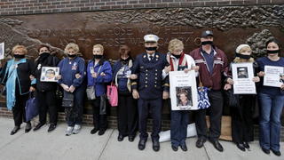 epa04199711 The parents of New York City Firefighter Chistopher Santora, who died on 9/11, Alexander Santora (C, in uniform), a retired Deputy Chief of the FDNY, his wife Maureen (5-L) and other victims' family members with black ribbons tied around their mouths protest the decision by New York city officials to keep unidentified human remains of 9/11 victims at the 11 September Memorial and Museum at the World Trade Center site, in New York, New York, USA, 10 May 2014. The unidentified remains were moved from the Office of the Chief Medical Examiner in Manhattan to a repository built under the National 11 September Memorial and Museum at the World Trade Center site. EPA/PETER FOLEY +++(c) dpa - Bildfunk+++