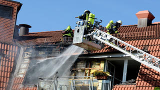 Feuerwehrmänner löschen am 30.05.2014 einen Brand in einem Seniorenheim in Schenefeld (Schleswig-Holstein). Bei dem Feuer sind laut Feuerwehrangaben zwei Menschen ums Leben gekommen. Foto: Daniel Reinhardt/dpa +++(c) dpa - Bildfunk+++