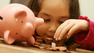 Recession teaches children value of money. Embargoed to 0001 Tuesday September 1, 2009. POSED BY MODELFile photo dated 16/02/07 of a child counting money from a piggy bank.  Issue date: Monday August 31, 2009. Two-thirds of parents think the economic downturn has helped them to teach their children about the value of money, research showed today. Two out of three parents with seven-year-olds said the recession had helped their children understand that &quot;money did not grow on trees&quot;, while a third thought it would make them more responsible when handling their own cash. See PA story MONEY Children. Photo credit should read: Anthony Devlin/PA Wire URN:7758658